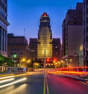 a city street at night with a tall building