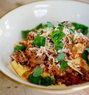 a white bowl of food with meat and vegetables