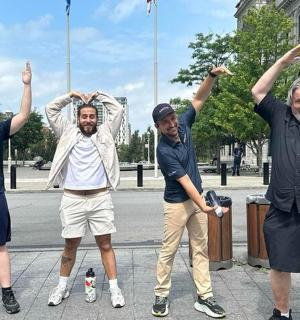 a group of three men holding their arms up
