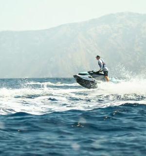 muž jedoucí na vlně na surfovém prkně v oceánu