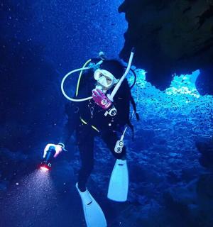 a man is standing in the water in a cave