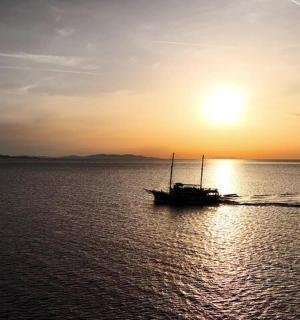 水中的小船，背景是日落