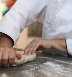 a chef is kneading a dough on a counter