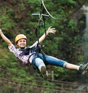 mladý chlapec visí na zip laně