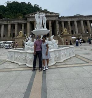 两个人站在一栋建筑前的喷泉前