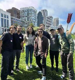 a group of people posing for a picture in a park