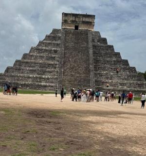 a group of people standing in front of a pyramid