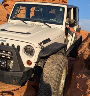 bílý džíp jedoucí v poušti