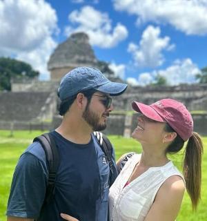 a man and a woman standing in front of a pyramid