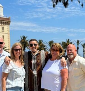 一群人在灯塔前摆姿势拍照