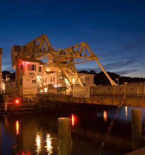 a large crane sitting on a bridge over the water