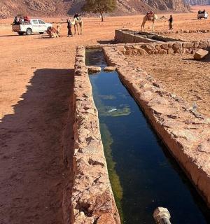 沙漠中的水渠，有人和车辆