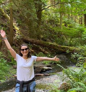 一位妇女站在森林里，双臂高举