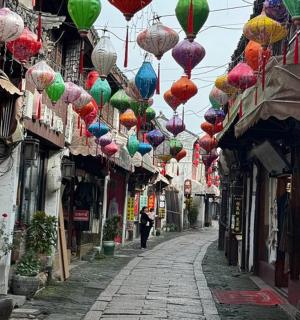 ulička s barevnými lucernami visícími nad ulicí