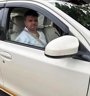 一名男子坐在一辆白色汽车的驾驶座上