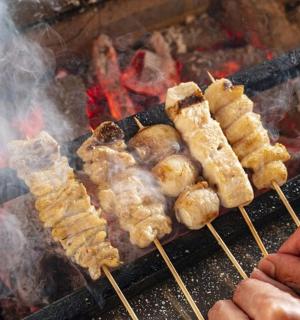 a bunch of food on sticks on a grill