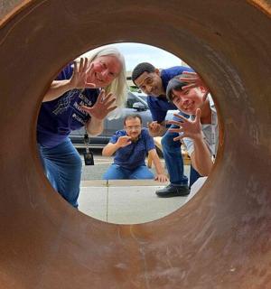 a group of people taking pictures in a mirror