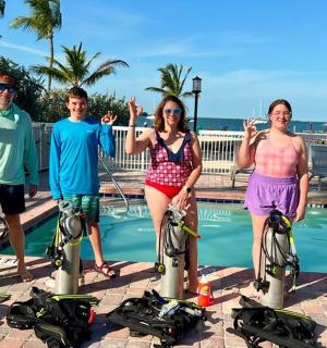 skupina lidí stojících vedle bazénu