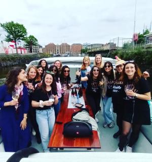 a group of women standing around a table on a boat
