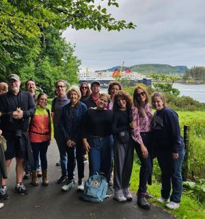 a group of people posing for a picture on a path near a lake