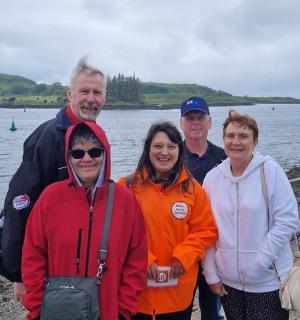 a group of people standing next to the water