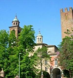 a building with two towers on top of it with trees