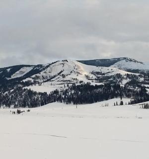 a snow covered mountain in front of a snow covered mountain