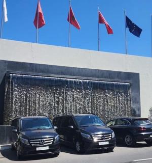 三辆汽车停在一座挂着旗帜的建筑物前