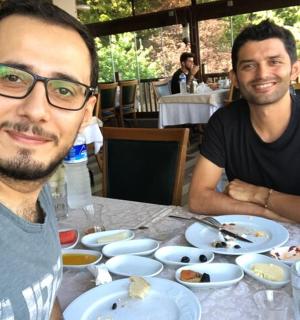 两个男人坐在桌旁，桌上摆着食物