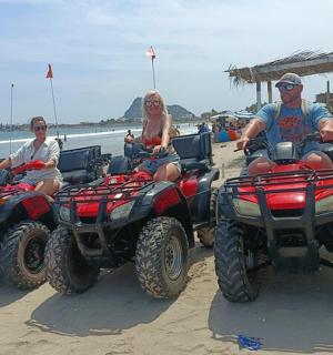 a group of people riding atvs on the beach