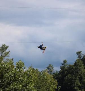 člověk letí ve vzduchu nad stromy