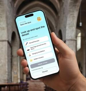 一个人在建筑物前拿着一部 iPhone