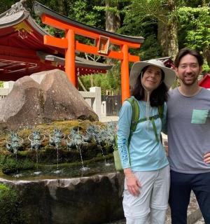 a man and a woman standing in front of a fountain