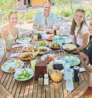 a group of people sitting around a table with food