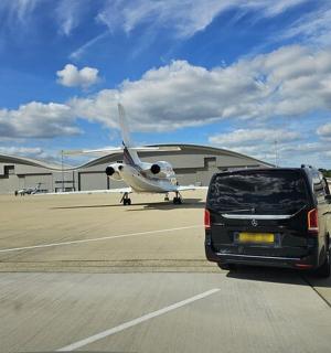 停在机场前的一辆汽车和一架飞机