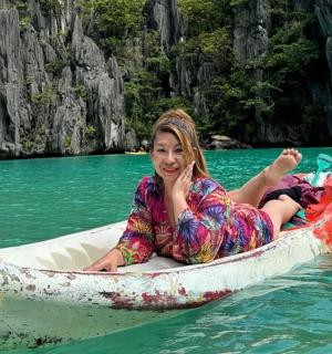 a woman is sitting in a boat in the water