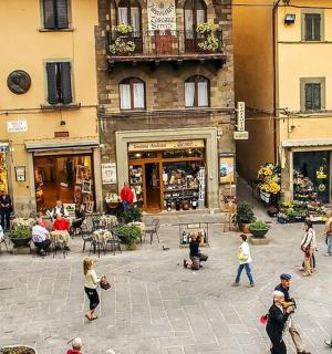 a group of people walking around a street with buildings