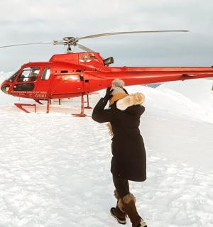muž stojící před červeným vrtulníkem
