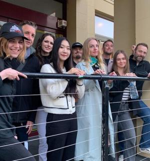 skupina lidí stojící za plotem