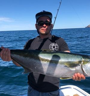 a man holding a large fish in the water
