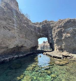 an archway in a rocky mountain with a body of water