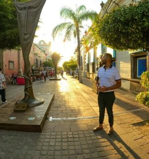 一名女子站在街边的雕像旁