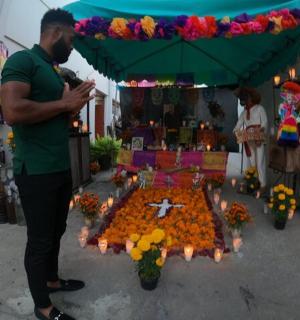 一名男子站在摆满鲜花的桌子前