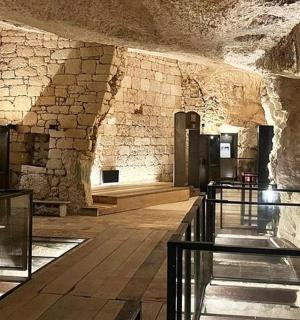 a large room with a stone wall and a hallway