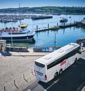 a bus parked in front of a marina with boats