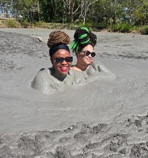 two women are standing in a hole in the sand