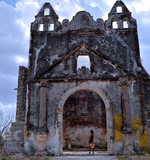 a woman standing in front of an old building