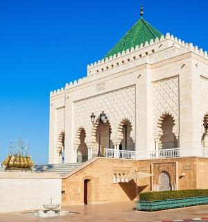 velká bílá budova se zelenou střechou