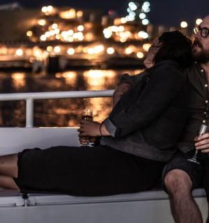 một người đàn ông và một người phụ nữ đang ngồi trên thuyền với đồ uống