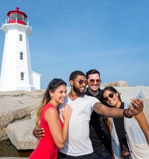 a group of people standing in front of a lighthouse